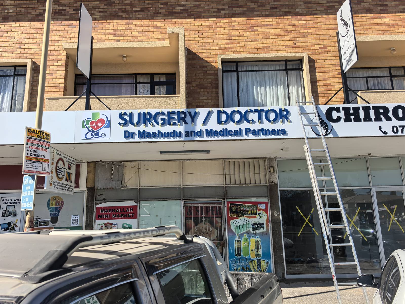 Surgery and doctor lettering above a shopfront with printed window graphics.